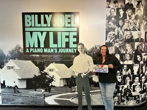 Longtime Billy Joel fan, Marnie Thomas, with a cutout of 15-year-old Joel. 